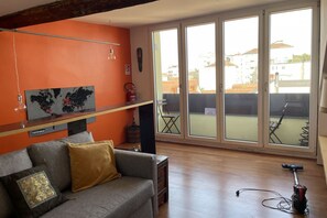A living room with a grey sofa, a world map on the wall, and a large sliding glass door leading to an outdoor area. - Paolo Sarpi, 36 - Milan Inside (Milan)