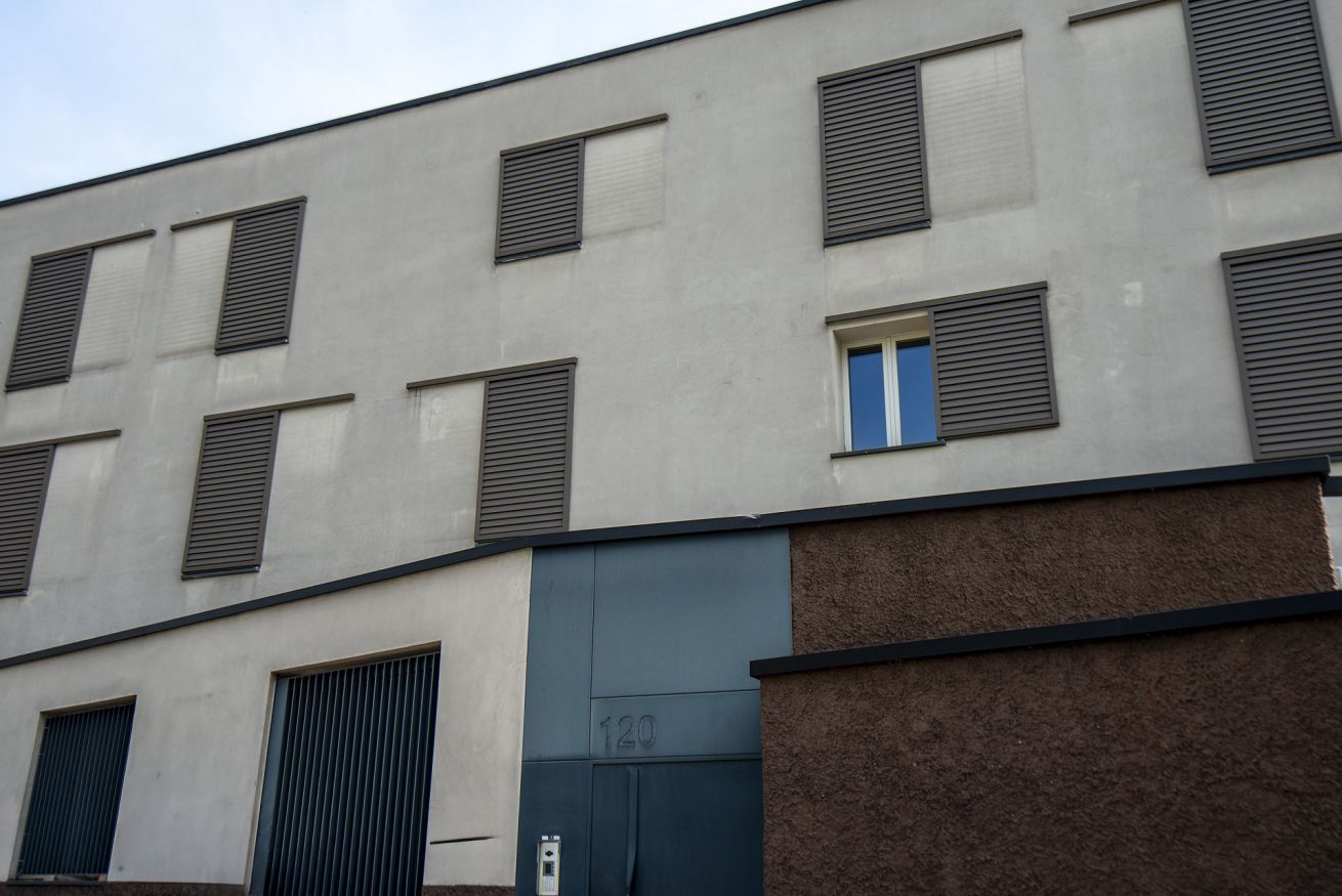 Un edificio con diverse finestre, un portone con la scritta '120' e una facciata strutturata.