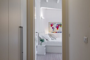 A modern bedroom with a bed, a nightstand, a wall art piece, and a white wardrobe. - UMBRIA, 120 - Comfortable and well-connected (Milano)