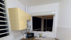 A compact kitchen with a built-in oven, a microwave, and a sink. - Ocean view appartement up to one of the most beautiful beach of the island (Le Gosier)