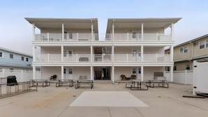 A multi-story building with balconies, outdoor seating, and a central entrance. - Peaceful 2-bedroom condo in Wildwood Crest, close to beach (Wildwood)