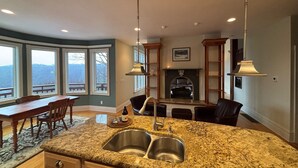 Un'ampia cucina con un'isola grande, scaffalature integrate e un camino.
