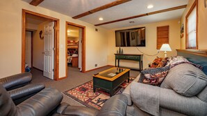A living room with a coffee table, sofa, and a television.
