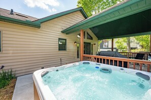 A house with a hot tub, a covered deck, and a garage. - New! Modern Lakeview Ski Retreat w/ Hot Tub (McHenry)