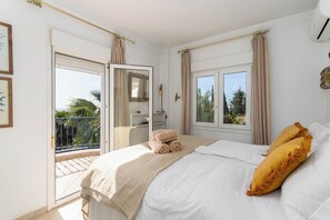 A bedroom with a bed, a window, a balcony, and a door. - Villa Pomona - Five Bedroom Villa, Sleeps 10 (Frigiliana)