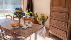 Ein Esstisch mit Geschirr, Tassen und einer Blumenvase.