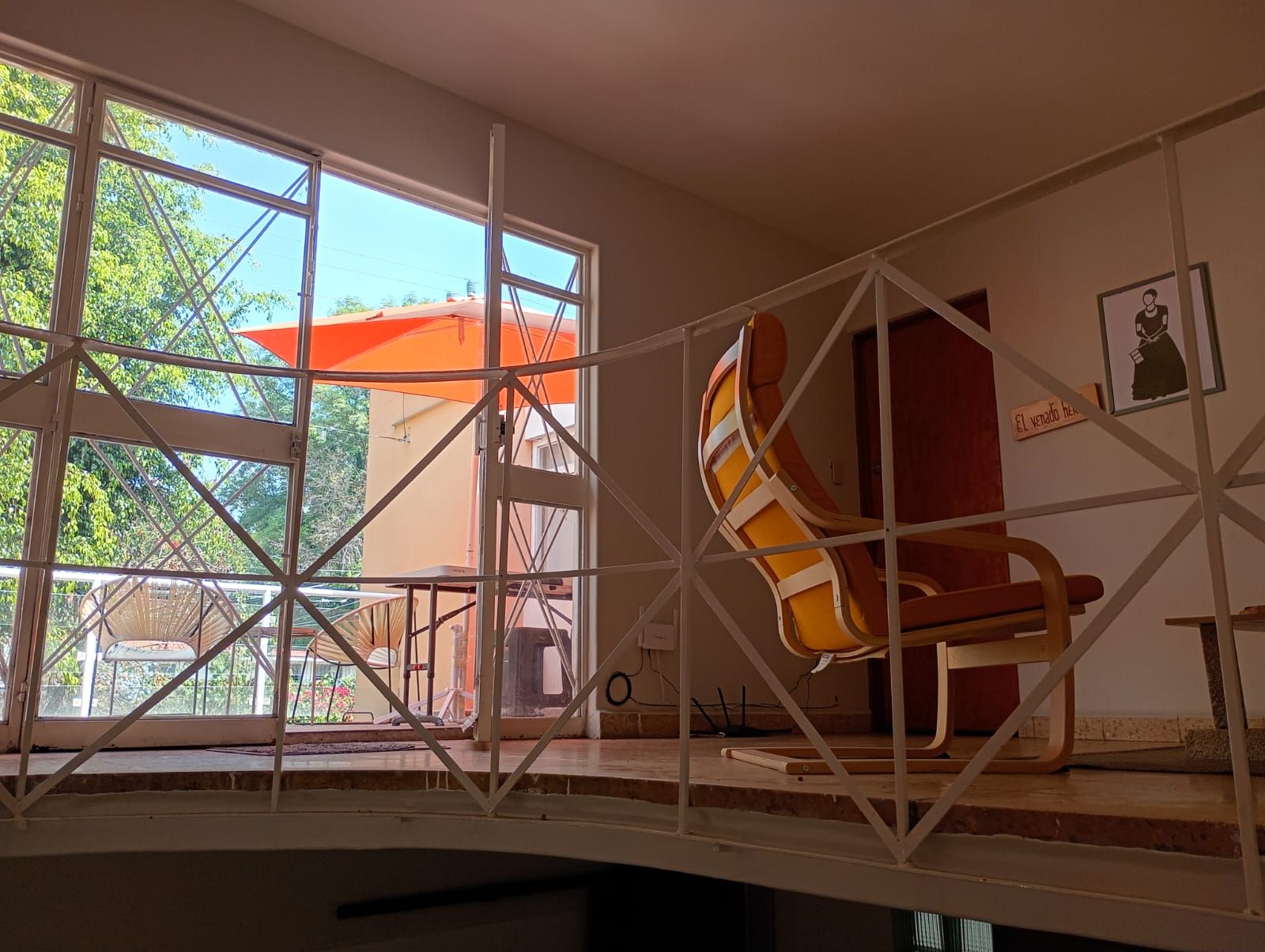 Una habitación con un ventanal grande, una silla y una puerta.