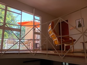 A room with a large window, a chair, and a door.