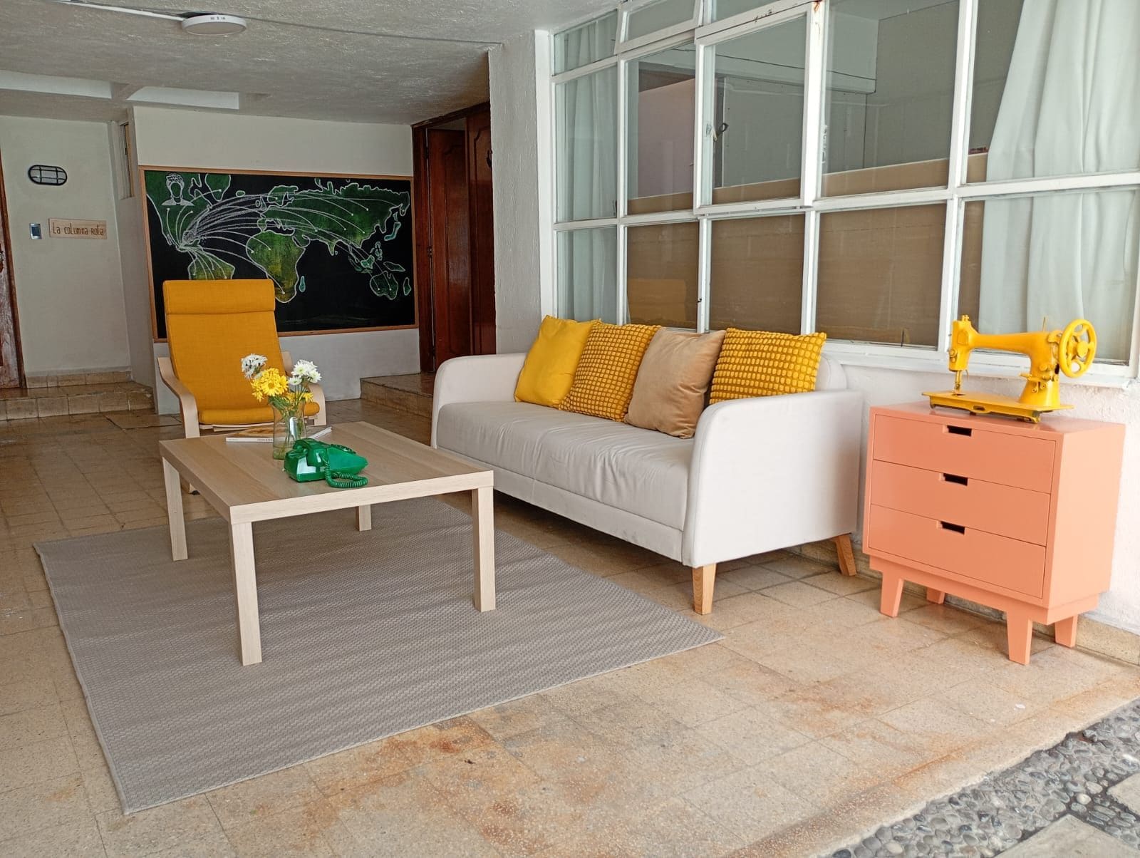Una sala de estar con sofá, una mesa de centro, una silla y un aparador.