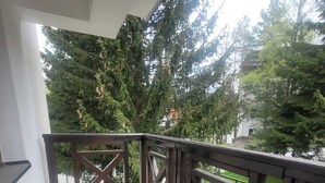 A balcony with a tiled floor, wooden railing, and a trash bin. - Soothing 1-bedroom apartment in awesome Kopaonik getaway (Kopaonik)