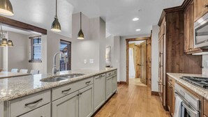 A modern kitchen with granite countertops, stainless steel appliances, and wooden cabinets. - Sunrise Gondola Lodge - Ski-in/ski-out (Park City)