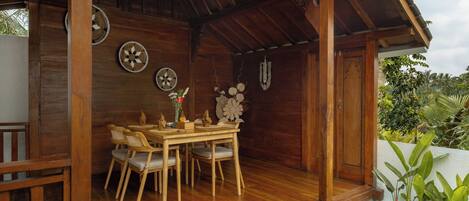 Un comedor de madera con una mesa, sillas, un ventilador y adornos en la pared.