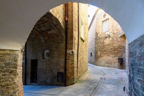 An arched stone corridor with a narrow path, brick walls, and a door. - GuestHost - A comfortable 64 square meters apartment, perfect for three people, located on the ground floor of a historic building with a private entrance.The property is located in the heart of Urbino's historic center (limited traffic zone). It also en (Urbino)