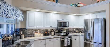 Fully stocked kitchen with granite countertops and stainless steel appliances