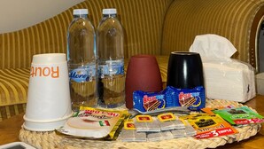 A room with a sofa, a table with snacks, drinks, and a remote control. - Abdali elite studio (Amman)