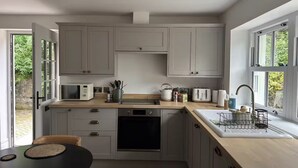 Une cuisine moderne avec des meubles gris, un four à micro-ondes, un grille-pain et un évier.