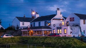 Un bâtiment blanc avec une enseigne indiquant « The Steamboat Inn » et « King Edward Cigars ».