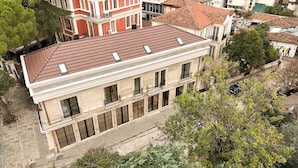 A multi-story building with a red-tiled roof, large windows, and balconies. - Post Inn  (Tirana)