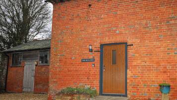 A brick building with a wooden door labeled "THE BULLPEN."