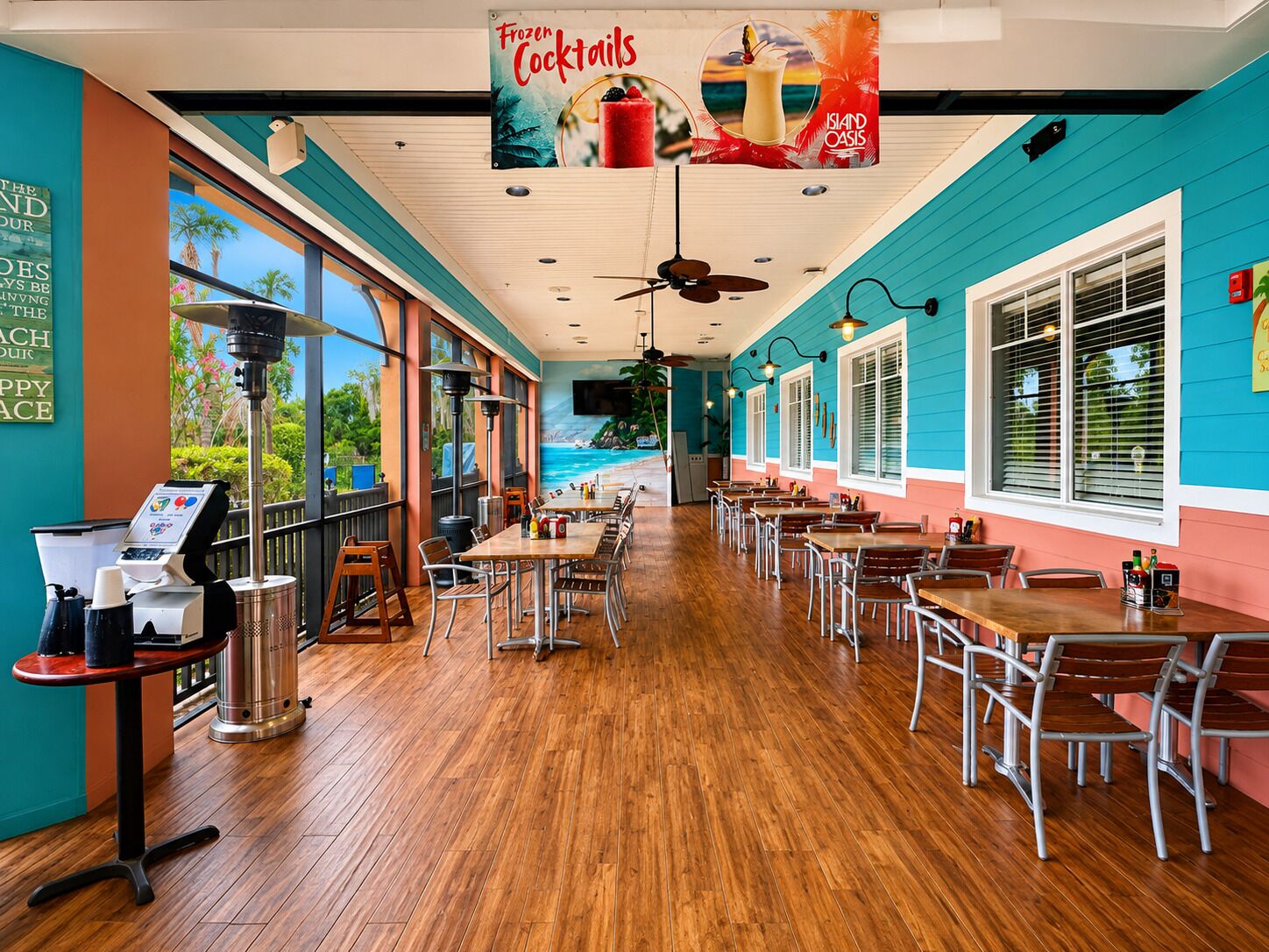 A restaurant with a beach view, wooden flooring, and a menu stand.