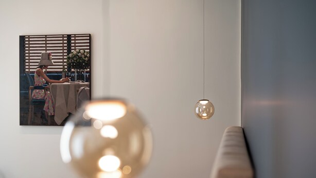 A modern living room with a sofa, a table with a vase of flowers, and a painting on the wall. - Casa Eva - Four Bedroom Apartment, Sleeps 10 (Naples)