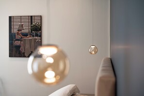 A modern living room with a sofa, a table with a vase of flowers, and a painting on the wall. - Casa Eva - Four Bedroom Apartment, Sleeps 10 (Naples)