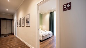 A hotel room with a bed, a door with the number 24, and framed pictures on the wall. - Casa Eva - Four Bedroom Apartment, Sleeps 10 (Naples)