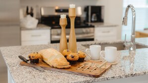 A kitchen counter with baked goods, a knife, and a cutting board. - Modern 3BR Centerton Near Walmart HQ & Bentonville (Centerton)