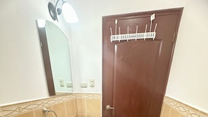 A compact bathroom with a toilet, sink, and a wooden door. - Beautiful bedroom shared house in charming León awaits you (León)