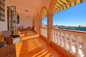 A terrace with a view, featuring a table and chairs, a railing, and a tiled floor. - Sara Sol in Frigiliana (Frigiliana)
