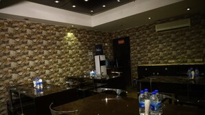 Restaurante con paredes de piedra, señal de salida de incendios y mesas con botellas de agua.