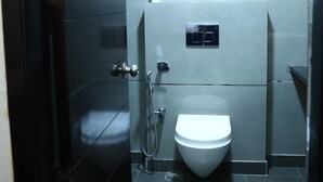 Un baño moderno con inodoro, ducha y toallero.