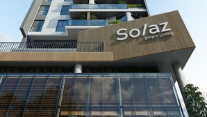 Ein Hochhaus mit mehreren Balkonen, einem Schild mit der Aufschrift 'Solaz Smart Living' und einem modernen architektonischen Design.