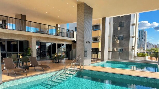 Ein Hotel mit Pool, Außenbereich und Blick auf die Stadt.