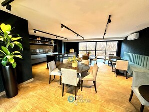 A modern interior with a dining area, kitchen, and seating. - Solaz Smart Living  (João Pessoa)
