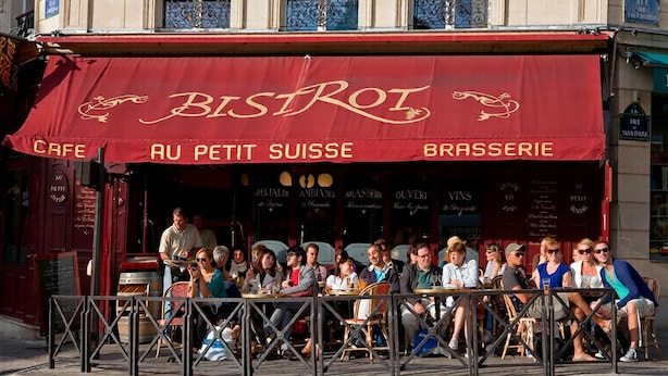 Een café genaamd BISTROT met terras en een rood luifel.