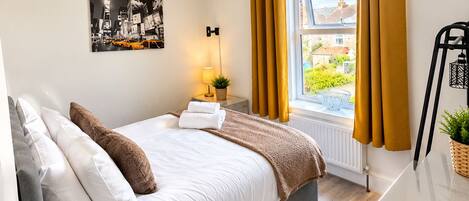 Bright cozy bedroom with stylish decor and plenty of natural light