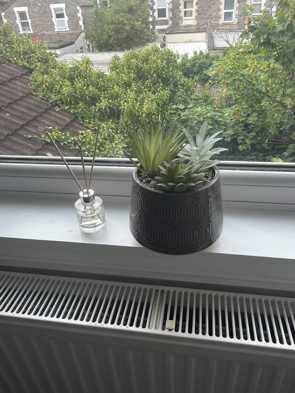A window sill with two potted plants and a vent. - Newly Redecorated 1 bed flat ! (Weston-Super-Mare)
