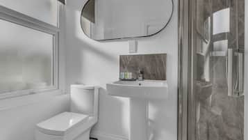 Un baño con inodoro, lavamanos y ducha.