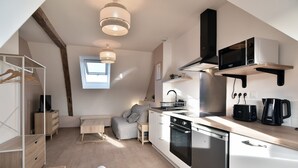 A compact kitchen with modern appliances, a dining area, and a cozy seating space. - Les Trois Rois 5 - Centre Avranches (Avranches)