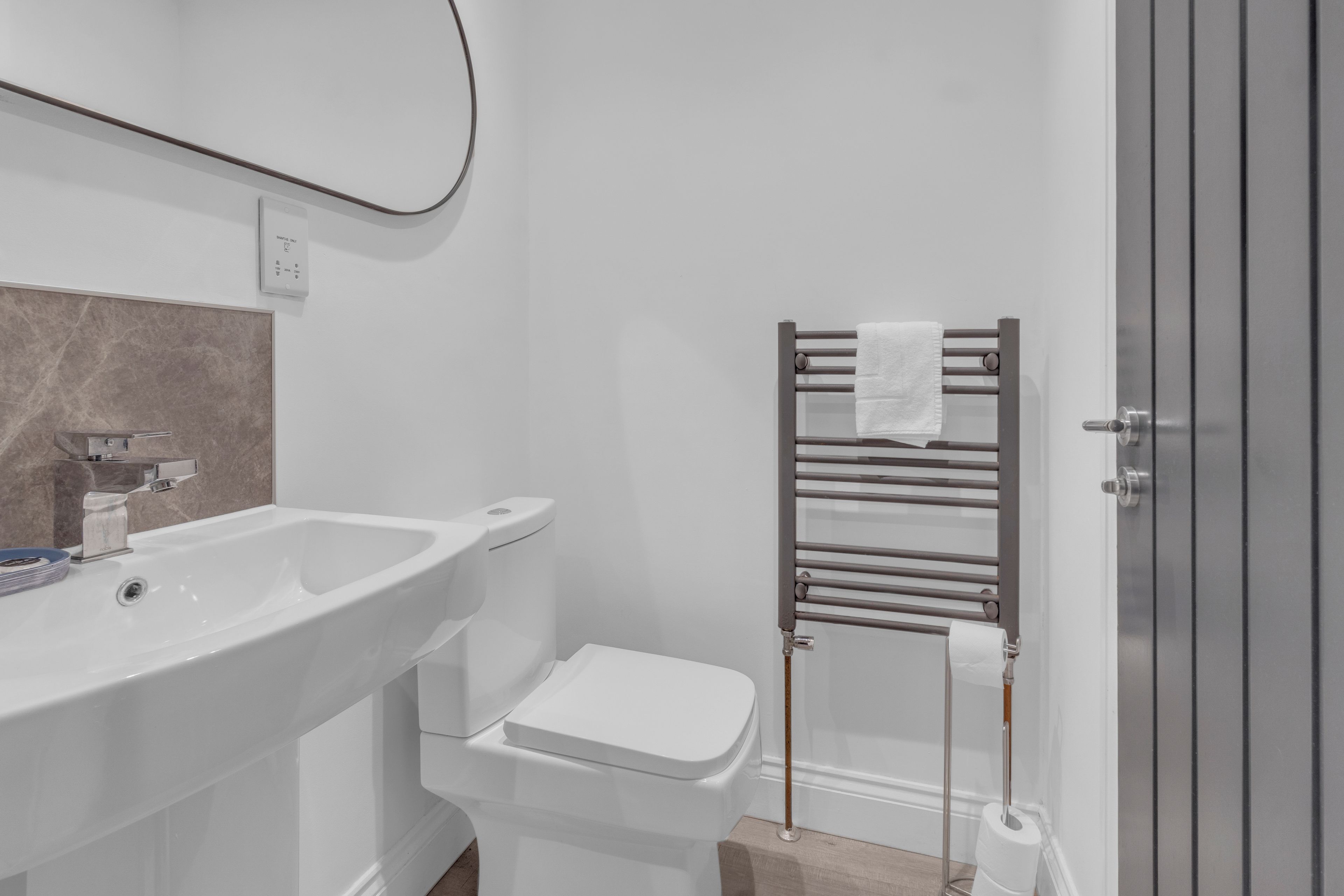 Bright modern bathroom with sleek finishes and heated towel rail