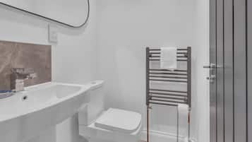A bathroom with a white sink, toilet, and towel rack.