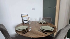 Taula de dinar amb quatre cadires, un menú emmarcat i copes de vi preparades per a quatre.