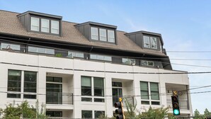 Um edifício moderno com vários andares, janelas amplas e telhado plano.