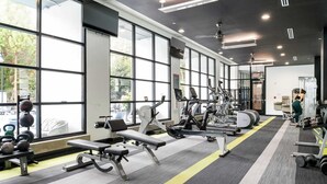 Uma academia com diversos equipamentos de exercício, janelas amplas e um design moderno e limpo.