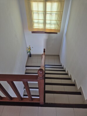 A staircase with wooden handrails and a light-colored floor. - Villa Adel: Oasis de paz con piscina climatizada (Playa Blanca)