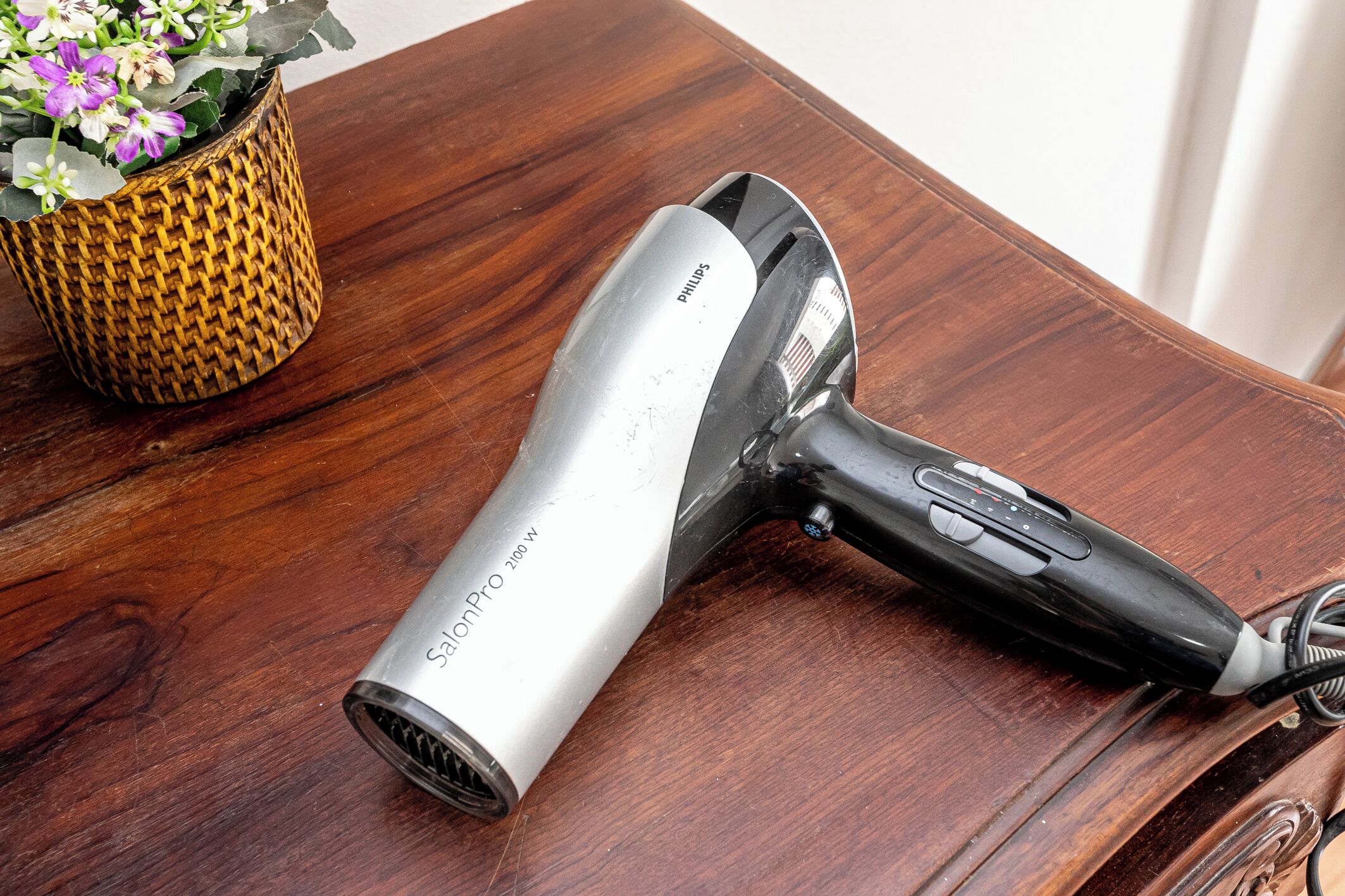 Un sèche-cheveux Philips SalonPro de 2100 W posé sur une table en bois.