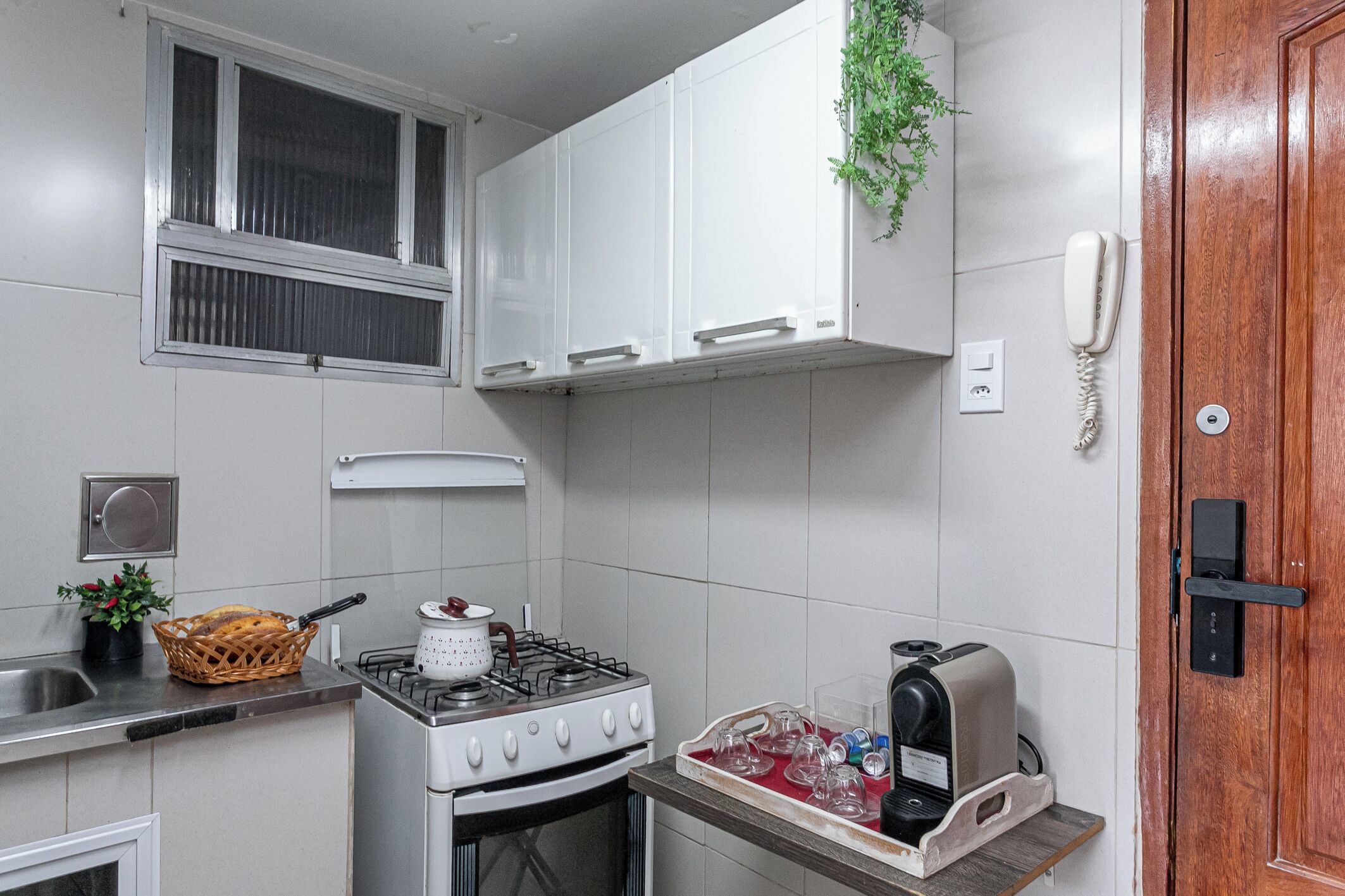 A compact kitchen with white cabinets, a gas stove, a toaster, and a small countertop.