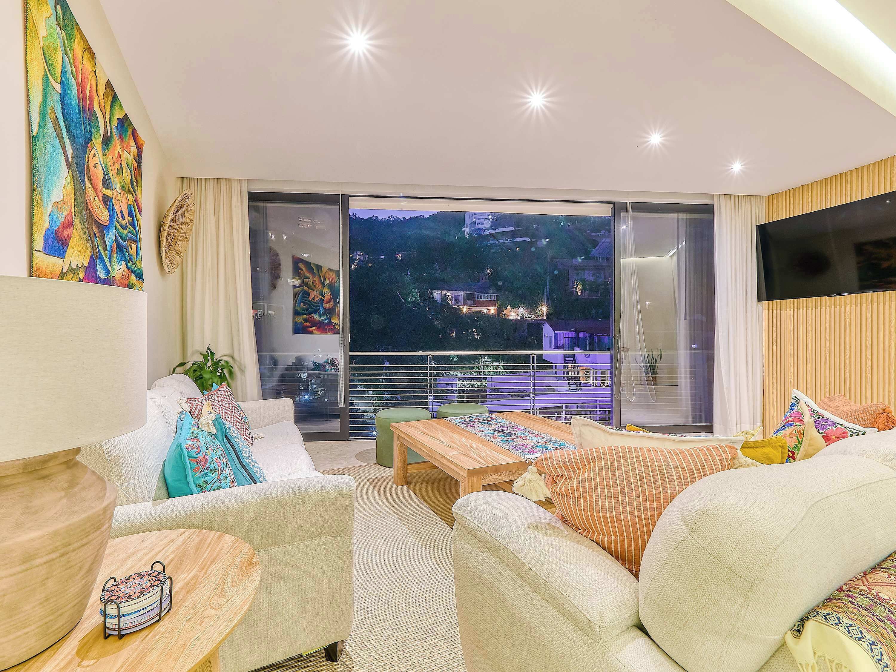 A modern living room with a sofa, coffee table, and artwork on the wall.