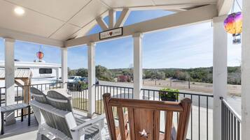 A covered outdoor area with a view of a boat named 'Columbus' in the background, a wooden chair with a star cutout, and a sign that says 'Family is the heart of everything'.